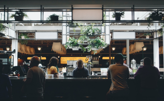 People sit at a bar in a busy restaurant 